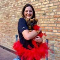 Woman in red tutu and black shirt holding brown puppy 