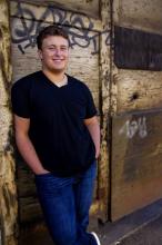 man standing in black shirt and blue jeans