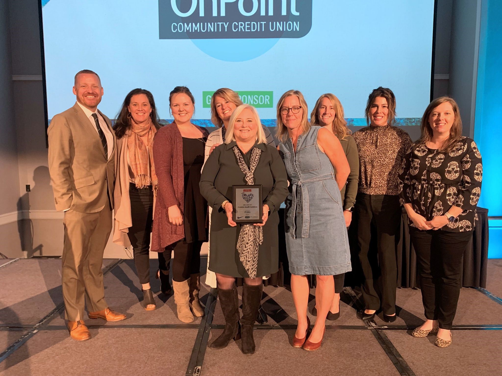 Group of smiling people with award