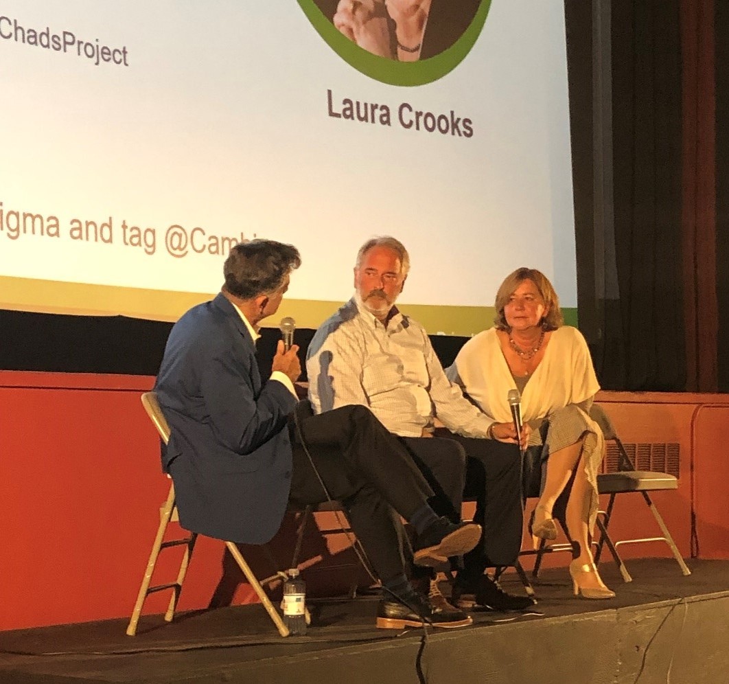 Speakers sitting on a stage talking with one another