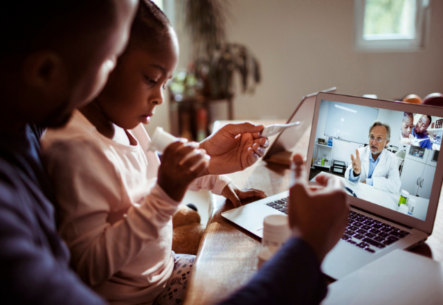 A father and daughter have a telehealth appointment with a doctor