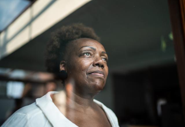 Older woman looking out of a window