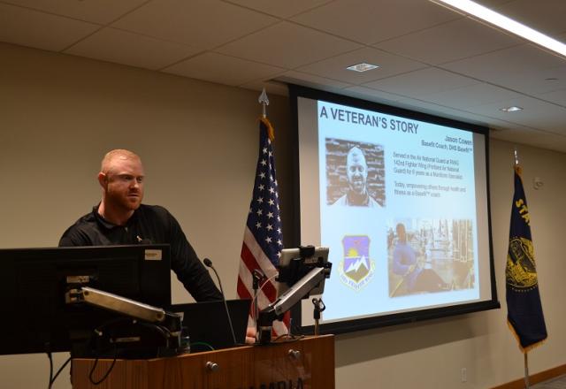 A speaker at the front of a room presenting