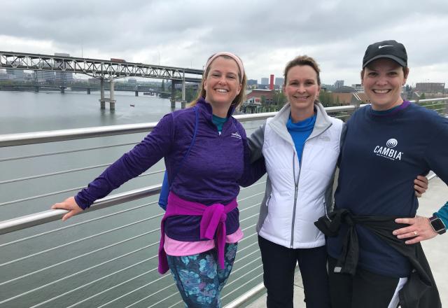 three women standing in front of water