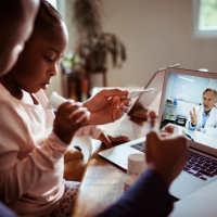 A father and daughter have a telehealth appointment with a doctor