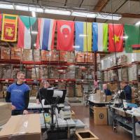 Volunteers in a warehouse packing donation boxes