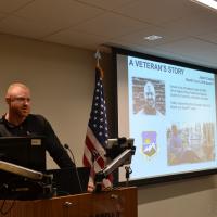 A speaker at the front of a room presenting