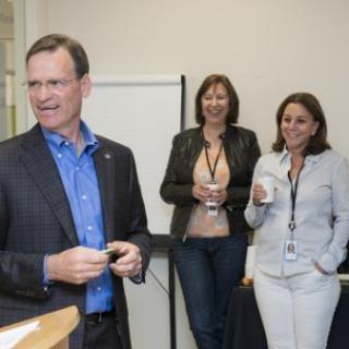 three people standing and smiling